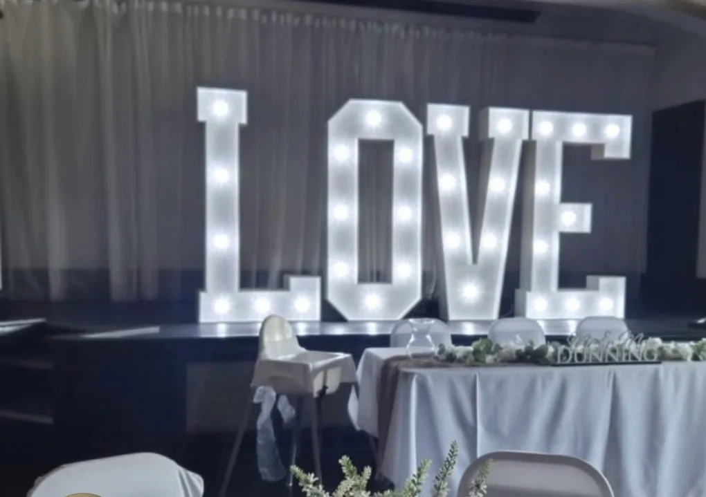 Illuminated LOVE letters behind a wedding top table